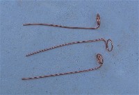 Pieces of copper wire inserted into concrete to tie track down